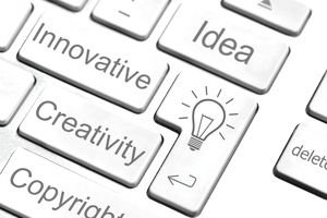 A person writing Intellectual Property and related words like copyright and trademarks on a white board.